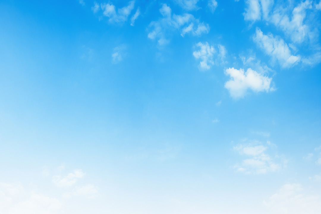 The image shows a clear blue sky with a few scattered clouds, and the horizon line is visible where the sky meets the land.