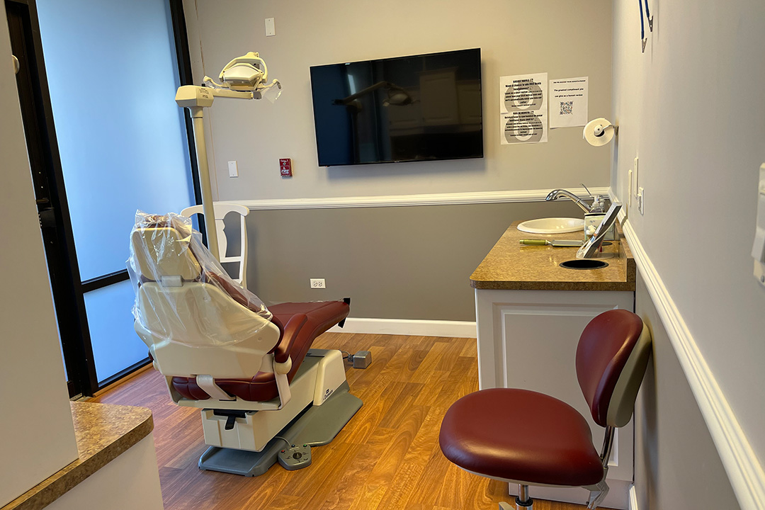 A dental office interior with a dentist s chair, examination table, and equipment.