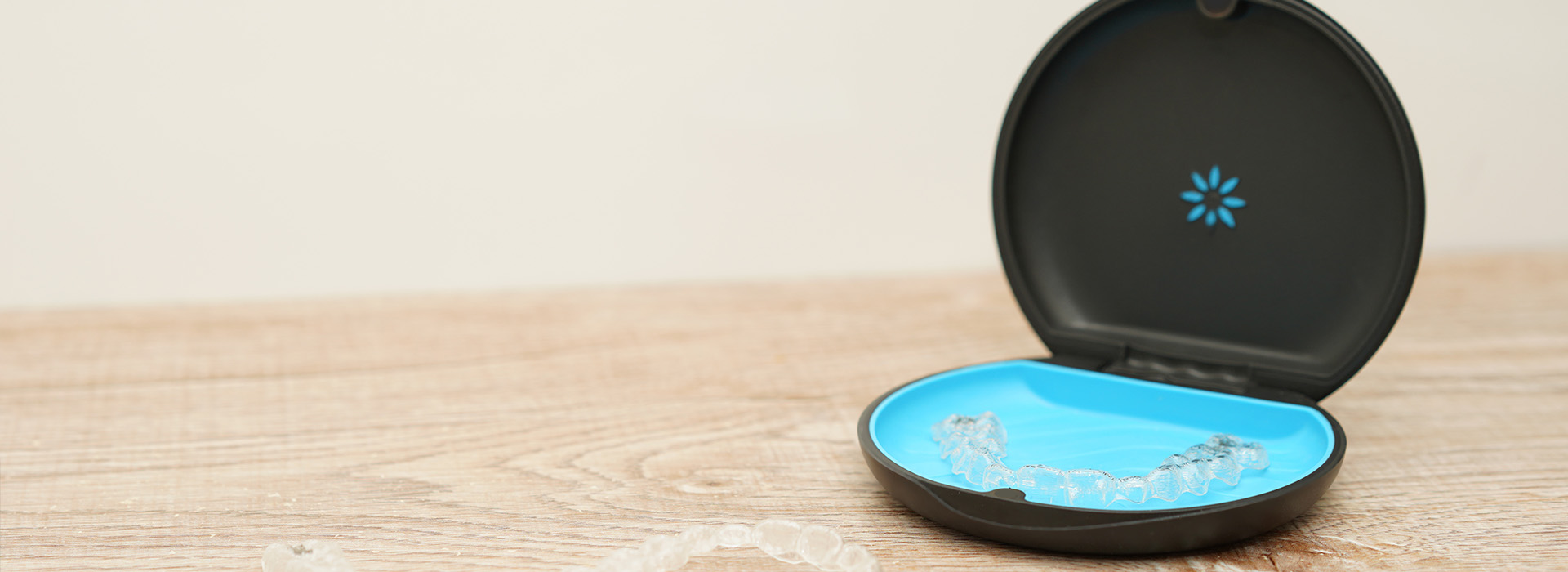 The image shows a smart device with a blue light on, placed on a flat surface against a plain background.