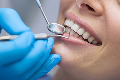 A person receiving dental care, with a dentist performing a procedure using specialized tools and equipment.