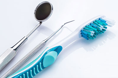 A dental tool set with a toothbrush and dental instruments on a white background.