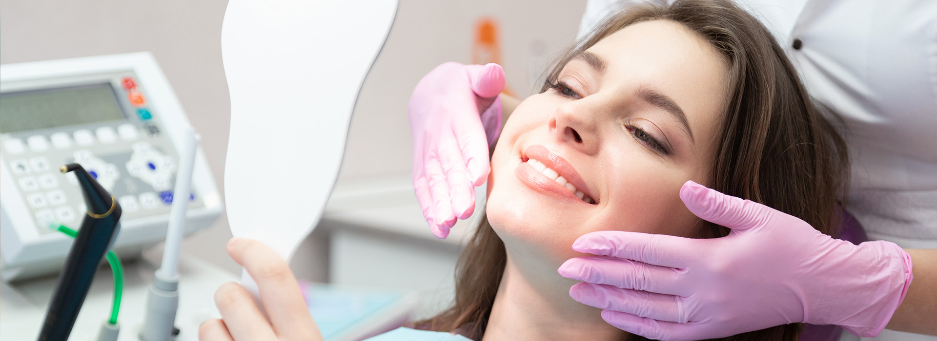 A woman sitting in a dental chair with her eyes closed, receiving dental care from a professional.