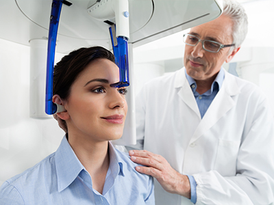 An image of a medical professional assisting a person with a dental device, possibly for teeth straightening or oral examination.