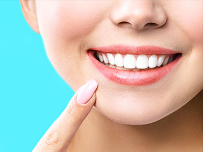 A smiling woman with a focus on her teeth, showcasing dental care or oral hygiene product.